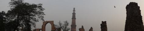 Panorama of Qutb Minar standing tall against the ruins